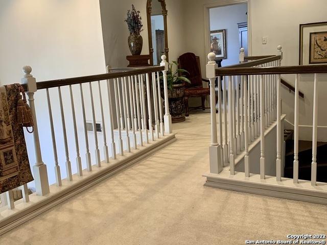 hall featuring carpet and an upstairs landing