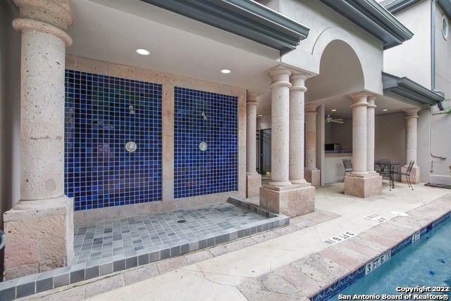 entrance to property with ceiling fan, a patio area, and a community pool