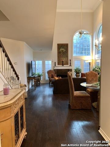 interior space with an inviting chandelier, ornamental molding, french doors, and dark hardwood / wood-style flooring