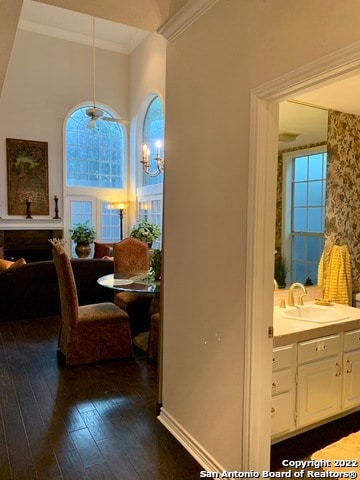 interior space with ornamental molding, dark hardwood / wood-style floors, sink, a high ceiling, and a notable chandelier