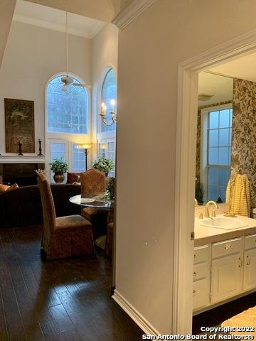 dining area with dark wood-style flooring and crown molding