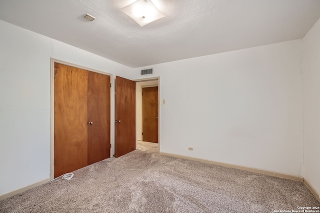 unfurnished bedroom featuring carpet flooring and a closet