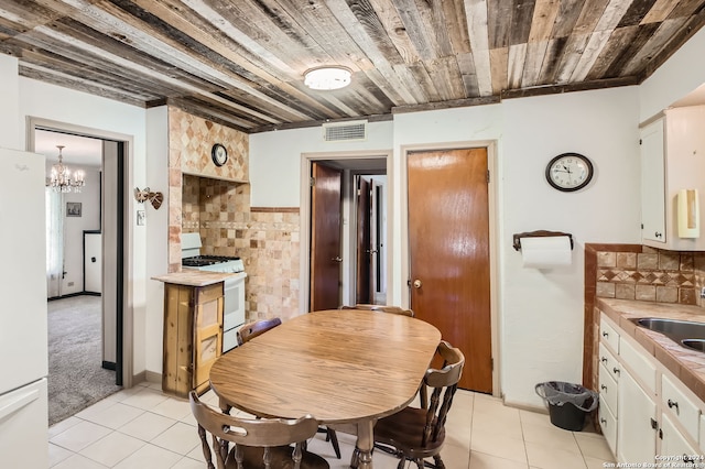 carpeted dining space featuring wood ceiling, an inviting chandelier, and sink