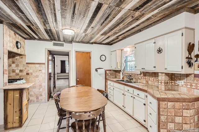 kitchen featuring white cabinetry, sink, tile countertops, and wood ceiling