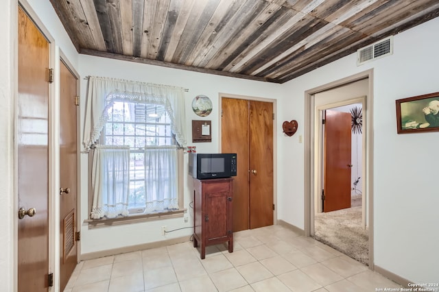 interior space with wooden ceiling and light tile patterned flooring