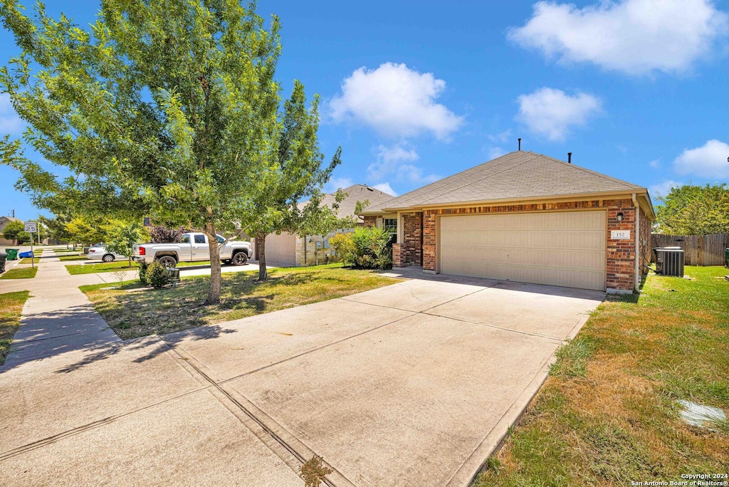 view of front of property with a garage, cooling unit, brick siding, and driveway