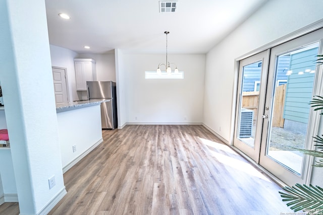 interior space featuring light hardwood / wood-style floors and a notable chandelier