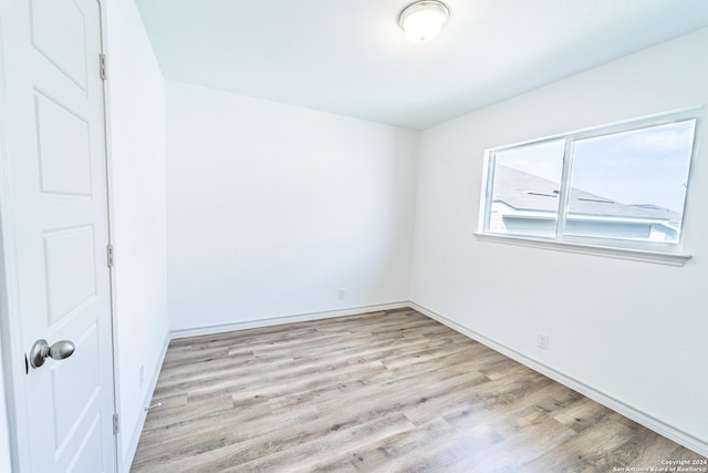 unfurnished room with light wood-style floors and baseboards