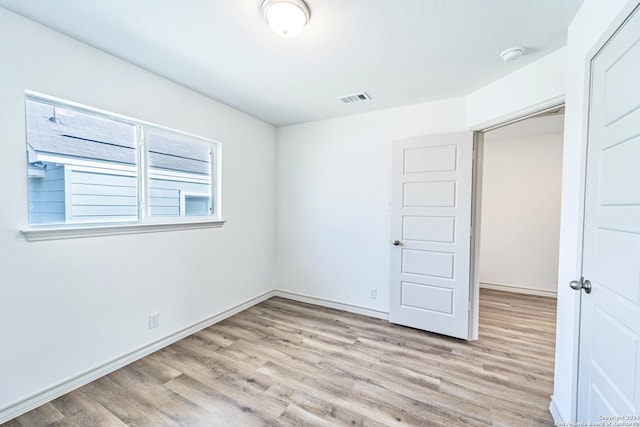 unfurnished bedroom featuring light wood finished floors, visible vents, and baseboards