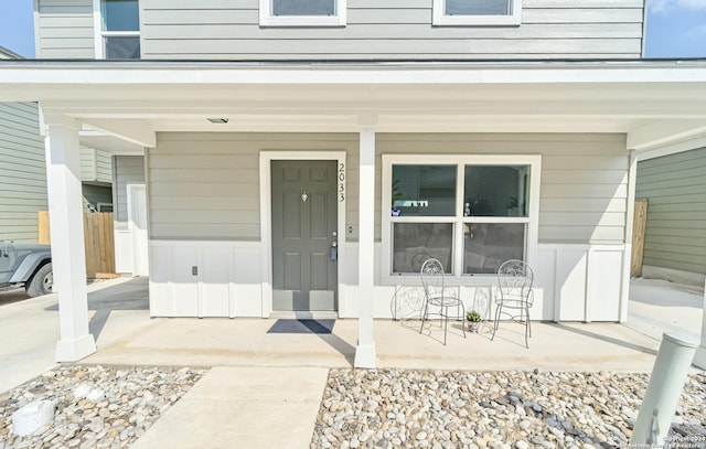 view of exterior entry featuring covered porch