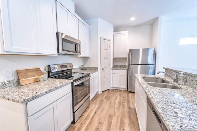 kitchen with sink, white cabinetry, stainless steel appliances, and light wood-type flooring