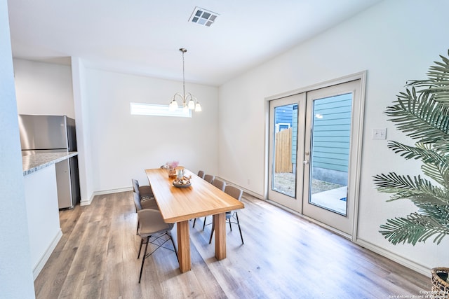 dining area featuring a chandelier, wood-type flooring, and a wealth of natural light