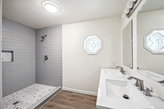 bathroom with tiled shower, vanity, and hardwood / wood-style flooring