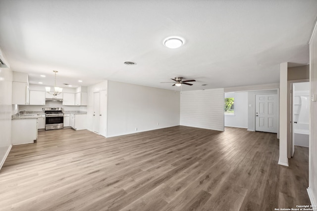 unfurnished living room featuring wood-type flooring, sink, and ceiling fan