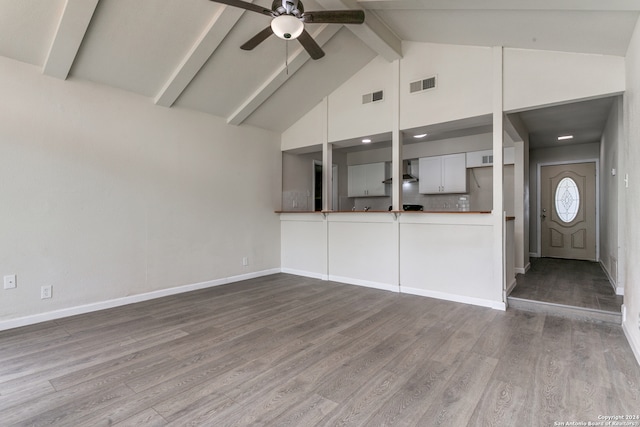 unfurnished living room featuring lofted ceiling with beams, ceiling fan, and hardwood / wood-style flooring