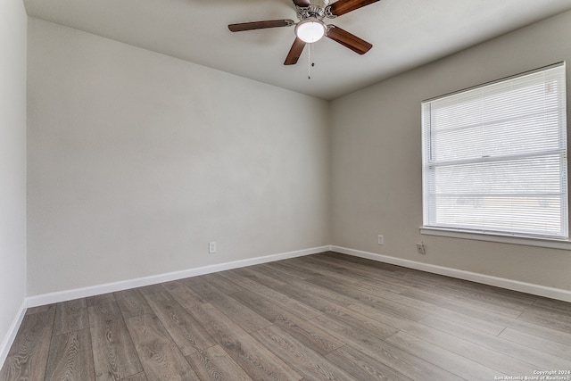 empty room with ceiling fan and hardwood / wood-style flooring