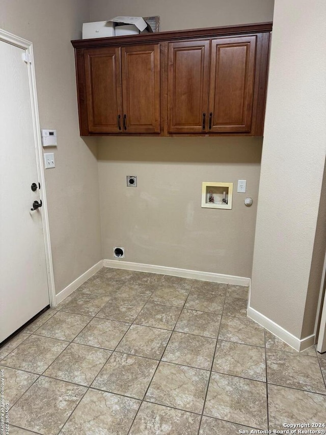 clothes washing area featuring electric dryer hookup, gas dryer hookup, cabinets, hookup for a washing machine, and light tile patterned floors