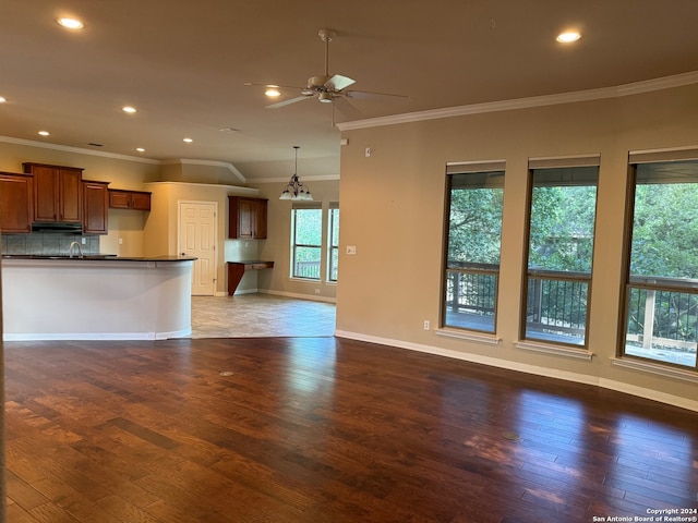 unfurnished living room with sink, ceiling fan, ornamental molding, and wood-type flooring