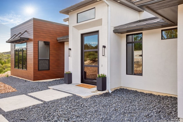 doorway to property featuring stucco siding