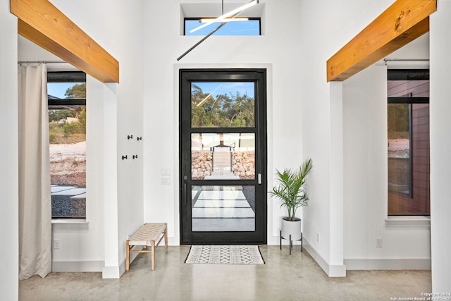 foyer with baseboards and finished concrete floors