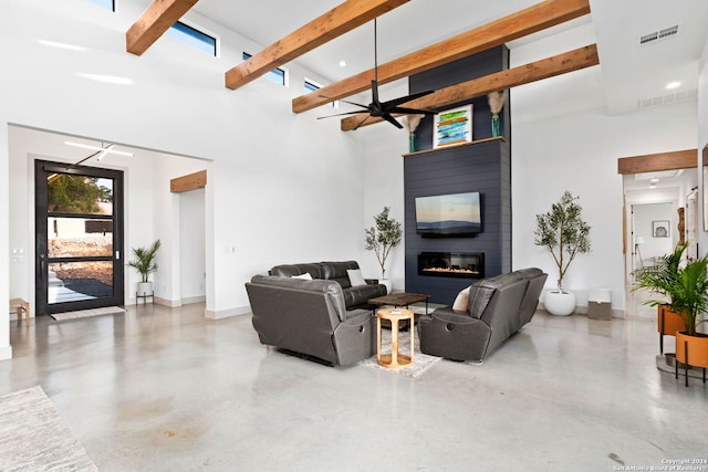 living area featuring visible vents, beamed ceiling, a fireplace, baseboards, and concrete flooring