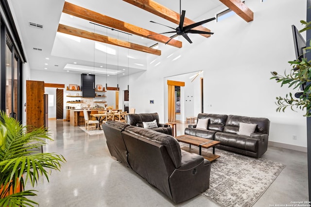 living area with visible vents, beam ceiling, recessed lighting, ceiling fan, and a towering ceiling