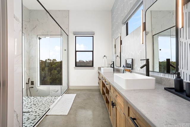 full bath featuring a wealth of natural light, a marble finish shower, and a sink