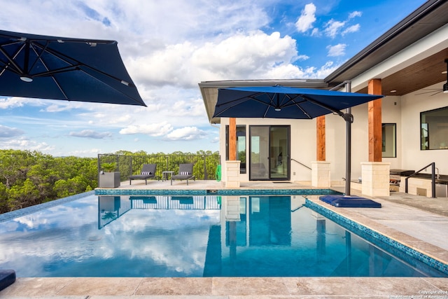 view of swimming pool featuring a patio area, a fenced in pool, and ceiling fan