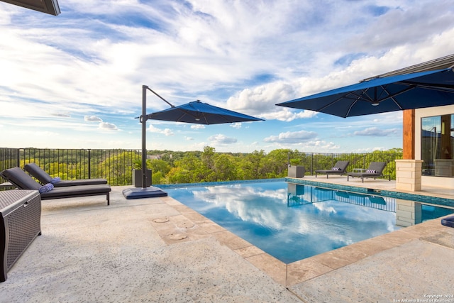 view of swimming pool with a patio, a fenced in pool, and fence