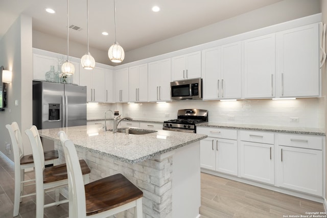 kitchen featuring sink, white cabinets, backsplash, and appliances with stainless steel finishes