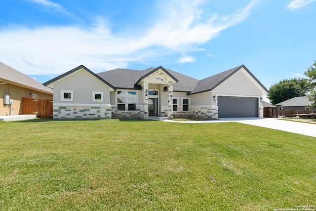 view of front of house with a garage, concrete driveway, stone siding, fence, and a front yard