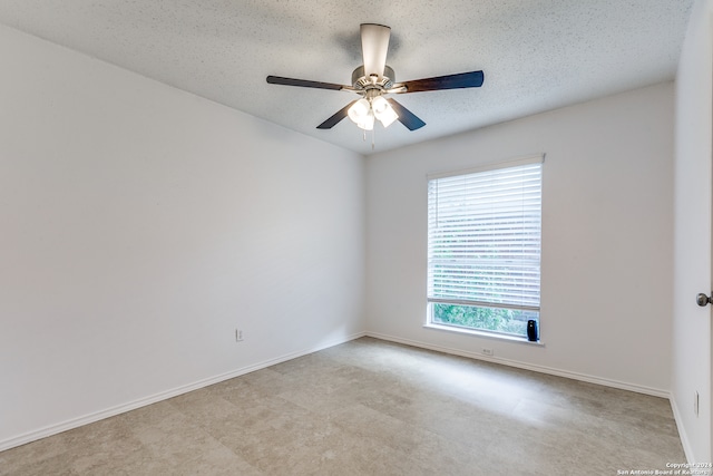 empty room with ceiling fan and a textured ceiling