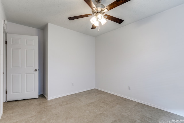 empty room with a textured ceiling, ceiling fan, and light carpet