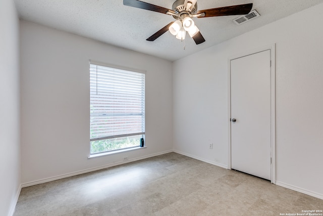 empty room featuring ceiling fan and a textured ceiling