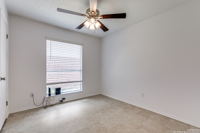 empty room with a textured ceiling, plenty of natural light, and ceiling fan