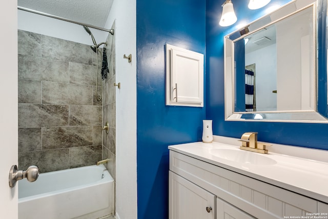 bathroom featuring tiled shower / bath combo, a textured ceiling, and vanity