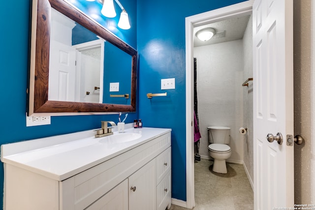 bathroom with toilet, vanity, and tile patterned floors