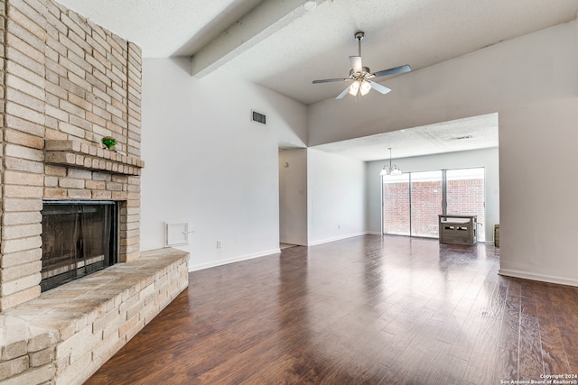 unfurnished living room with dark hardwood / wood-style floors, ceiling fan with notable chandelier, beam ceiling, a fireplace, and a textured ceiling