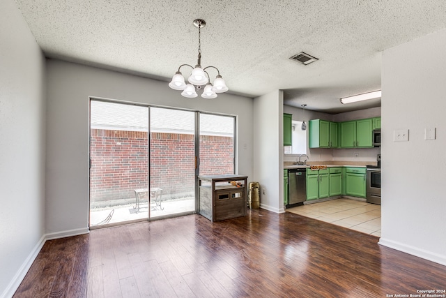 unfurnished living room featuring sink, a textured ceiling, a chandelier, and light tile patterned floors