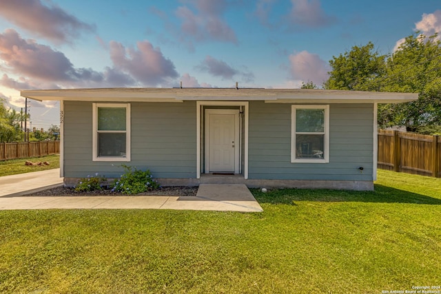 view of front facade featuring a front lawn and fence