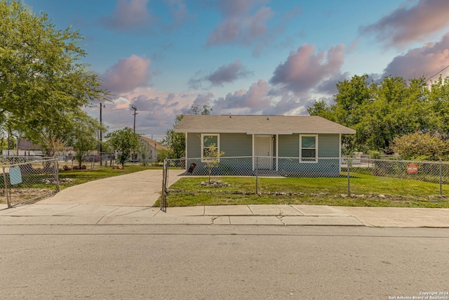 view of front of house featuring a front lawn, driveway, and a fenced front yard