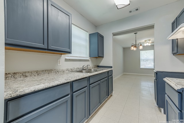 kitchen with sink, a chandelier, light tile patterned floors, and hanging light fixtures