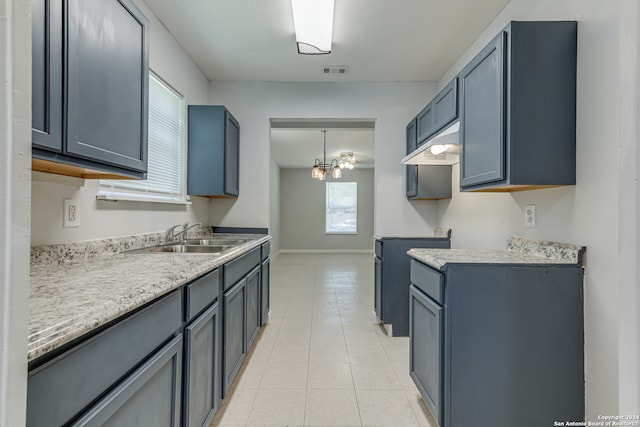 kitchen featuring custom range hood, sink, a notable chandelier, light tile patterned flooring, and hanging light fixtures