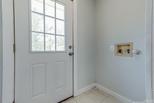 entryway with light tile patterned floors and baseboards