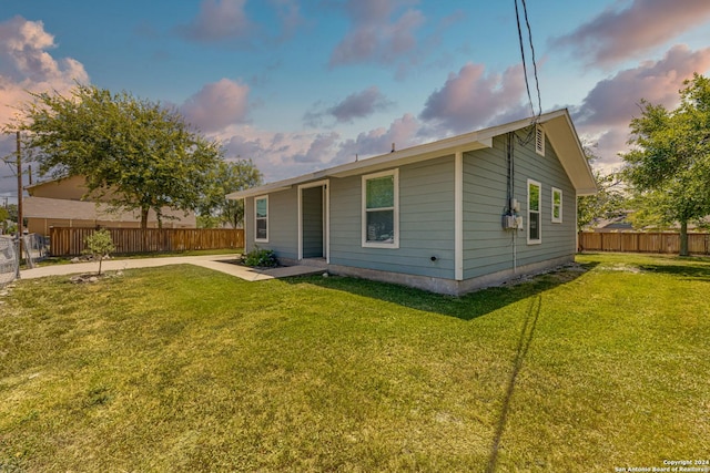 back of property with a patio area, a yard, and fence