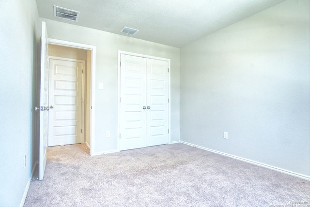 unfurnished bedroom with carpet and a closet