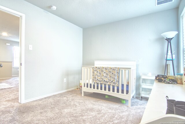 carpeted bedroom with a crib