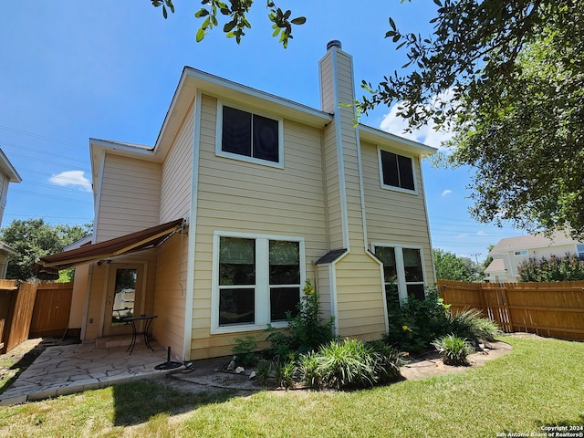 rear view of property with a patio area and a lawn