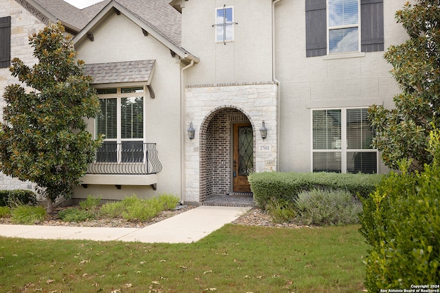 view of exterior entry featuring a yard