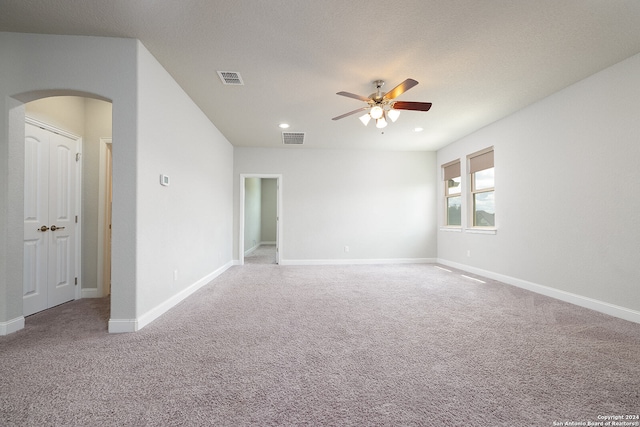 carpeted spare room with a textured ceiling and ceiling fan